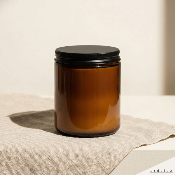 ardeluz NACRE soy candle in amber glass jar with matte black lid on natural linen